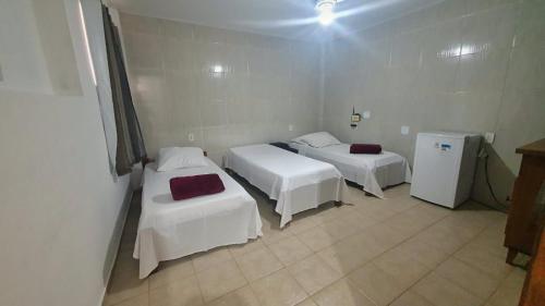 a room with two beds and a refrigerator at Quintal da Canastra - Room in São João Batista do Glória