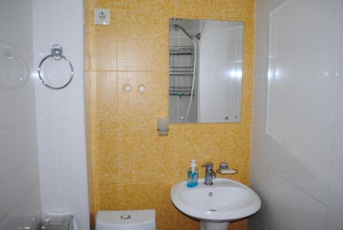 uma casa de banho com um lavatório, um espelho e um WC. em SWEETHOSTEL em Tbilisi
