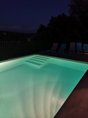 une piscine éclairée la nuit dans l'établissement Villa d'été, à Carcès