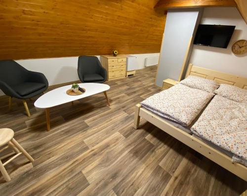 a bedroom with a bed and a table and chairs at Apartmán u rybníka in Sobotín