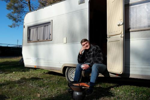 a man sitting in the doorway of an rv at Kamping, trailer Molly in Ulcinj