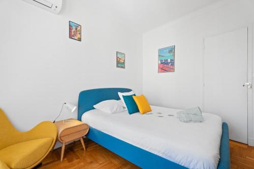 - une chambre avec un lit bleu et une chaise dans l'établissement Terrasse des Oliviers, à Nice