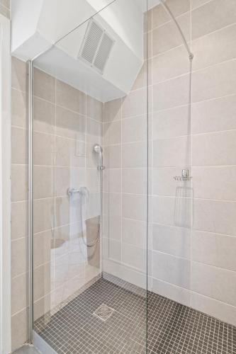 une douche avec une porte vitrée dans une salle de bain dans l'établissement Terrasse des Oliviers, à Nice