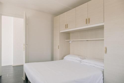 a bedroom with a white bed and white cabinets at M14 SkyView City Center in Padova