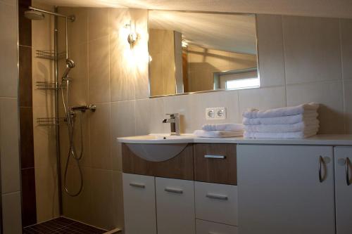 a bathroom with a sink and a shower with a mirror at Ferienwohnung Kitzbichler im Kaiserwinkl in Kössen