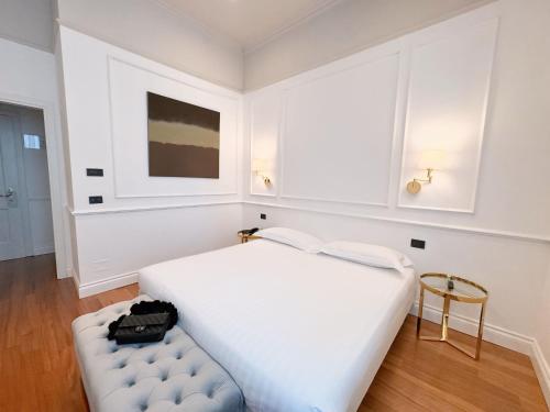 una camera bianca con un letto bianco e uno sgabello di Rechigi Park Hotel a Modena