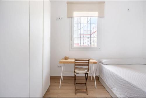 a small bedroom with a table and a bed at Acogedor y precioso apartamento en Sevilla in Seville