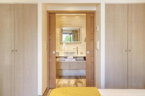 La salle de bains est pourvue d'un lavabo et d'un miroir. dans l'établissement Akwabay - Les Villas du Cap, au Lavandou
