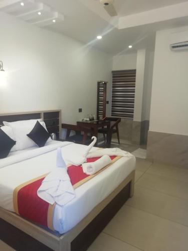 a large bed in a room with a table at PAUL RESIDENCY in Nedumbassery