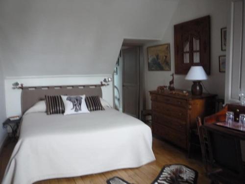 Un dormitorio con una gran cama blanca y una cómoda. en Les Pensees Chambre Hemingway, en Orléans
