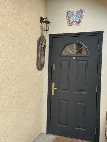 a black door with a butterfly on the wall at Agroturystyka Staroscin in Rzepin