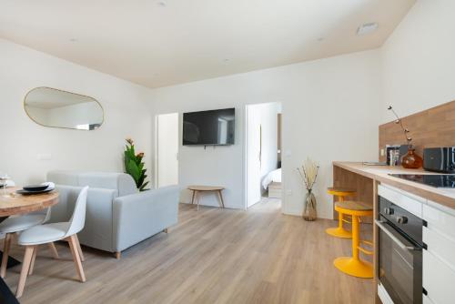 une cuisine et un salon avec un canapé et une table dans l'établissement Sariette - Spacieux - Linge hôtelier - Fibre - Confort, à La Destrousse