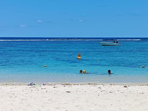 a group of people swimming in the water at the beach at Cathy´s Home in Flic-en-Flac