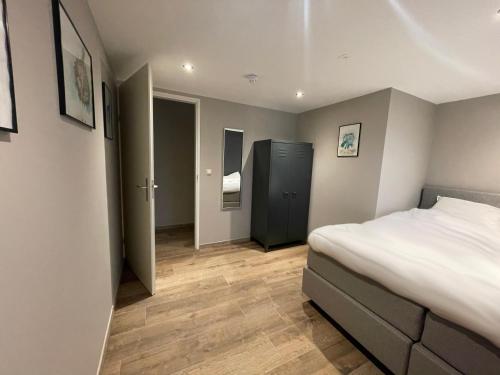 een slaapkamer met een bed en een hal met een deur bij In de Witte Dame Hotel Bar Kitchen Apartments in Grubbenvorst