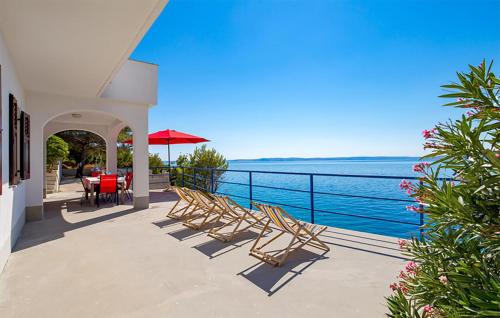 a patio with chairs and tables and a view of the ocean at Amazing Apartment In Jablanac in Jablanac