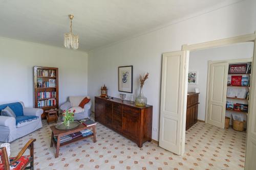 uma sala de estar com um sofá e uma mesa em Bed & Breakfast Barbera e Tulipani em Scandeluzza