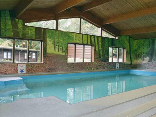 a swimming pool in a building with windows at Low Tarn Lodge in Elterwater