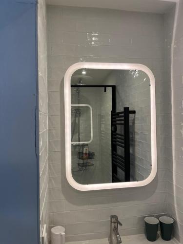 une salle de bain avec un miroir et un lavabo dans l'établissement Maison Le Coteau Plage vue mer, 8 pers. Petit Caux, à Saint-Martin-Plage