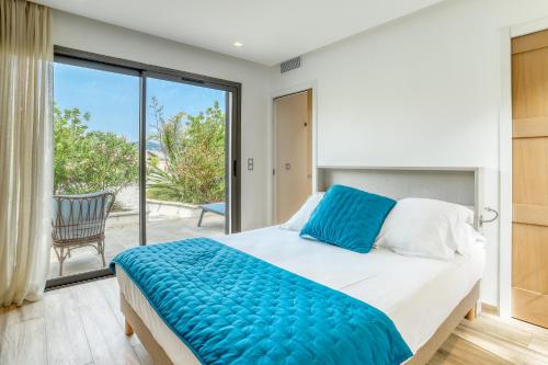 een slaapkamer met een groot bed en een balkon bij Akwabay - Les Villas du Cap in Le Lavandou