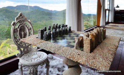 a chess board and a chair in a room with a window at Canto dos Prazeres Lavras Novas in Lavras Novas