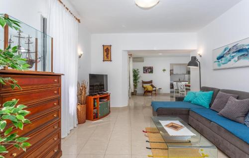 a living room with a blue couch and a table at 3 Bedroom Pet Friendly Home In Omisalj in Omišalj