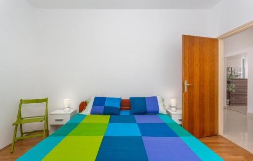 a bedroom with a bed with a colorful bedspread at 3 Bedroom Pet Friendly Home In Omisalj in Omišalj