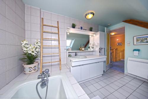 ein Badezimmer mit einem Waschbecken und einer Badewanne in der Unterkunft Maison Lutène - Avec jardin terrasse in Sartilly