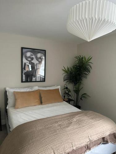 a bedroom with a bed and a potted plant at Countryside 2 bed cottage- Aylesbury in Haddenham