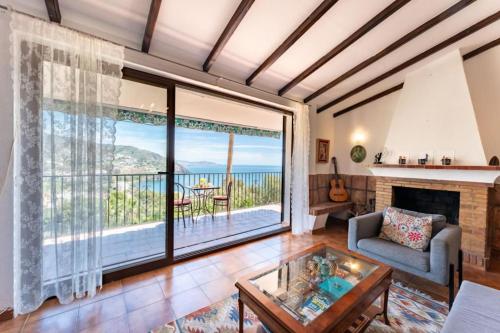 a living room with a fireplace and a view of the ocean at CT 269 GR - Faro's Sun, Beach & More in Almuñecar in Almuñécar