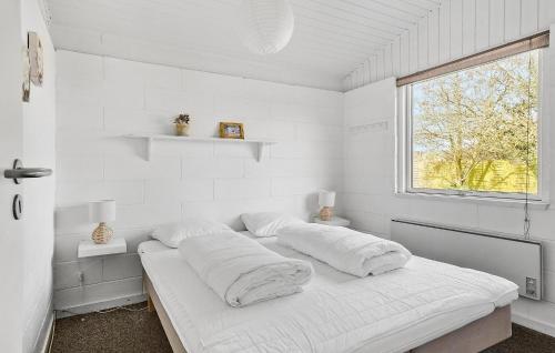 ノーポにあるBeautiful Home In Nordborg With 3 Bedrooms And Wifiの白い部屋(枕付きのベッド、窓付)