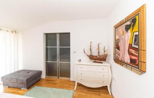 um quarto branco com uma cómoda e uma pintura na parede em 3 Bedroom Awesome Apartment In Kastel Gomilica em Kaštela
