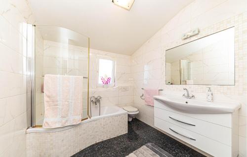La salle de bains est pourvue d'un lavabo, de toilettes et d'un miroir. dans l'établissement 3 Bedroom Awesome Apartment In Kastel Gomilica, à Kaštela