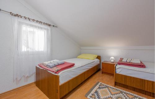 two twin beds in a room with a window at Nice Apartment In Potocnica With House Sea View in Borovići