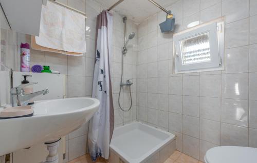 a white bathroom with a sink and a shower at Nice Apartment In Potocnica With House Sea View in Borovići