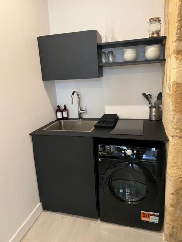 une cuisine avec un évier et une machine à laver dans l'établissement Duplex Atypique, à Bordeaux