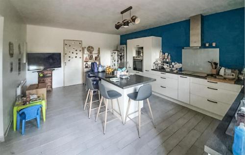 une cuisine avec des murs bleus et une table et des chaises dans l'établissement Stunning Home In Sarrians, à Sarrians
