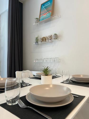 une table avec une plaque blanche et des verres sur celle-ci dans l'établissement Duplex Atypique, à Bordeaux