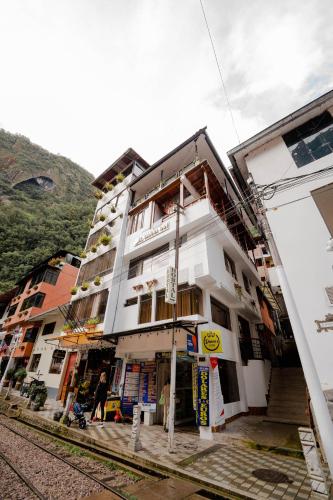 a white building with balconies on the side of it at DANNA INN in Machu Picchu