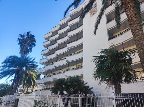 a tall building with palm trees in front of it at Salou Sol in Salou