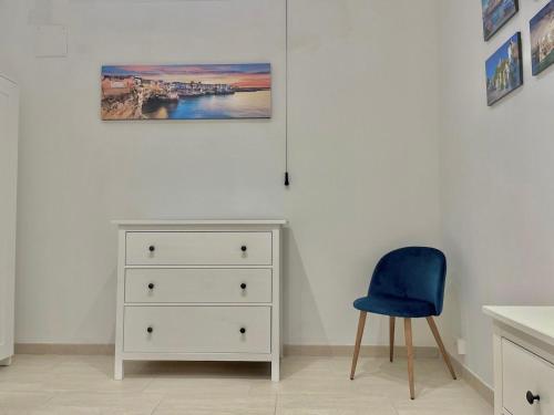 - une chambre avec une commode blanche et une chaise bleue dans l'établissement Villa vista mare, à Santo Spirito