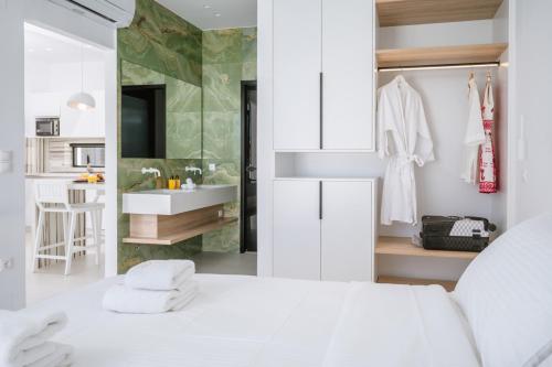 a bedroom with a white bed and a bathroom at Sardines Luxury Suites in Hersonissos