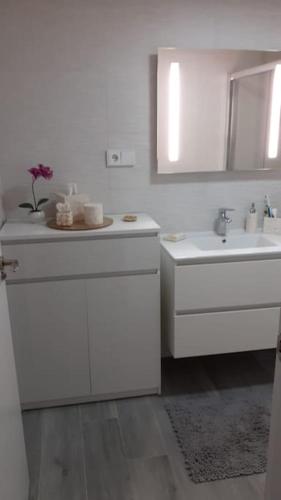 a white bathroom with a sink and a mirror at Camporrosso Pool View Apartment in Finestrat