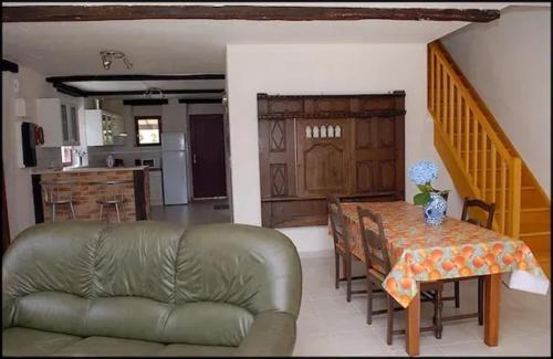 ein Wohnzimmer mit einem Sofa und einem Tisch sowie eine Küche in der Unterkunft Maison de 4 chambres avec jardin amenage a Inzinzac Lochrist 