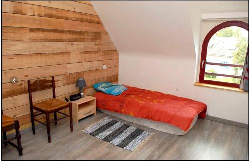 ein Schlafzimmer mit einem Bett, einem Tisch und einem Stuhl in der Unterkunft Maison de 4 chambres avec jardin amenage a Inzinzac Lochrist 