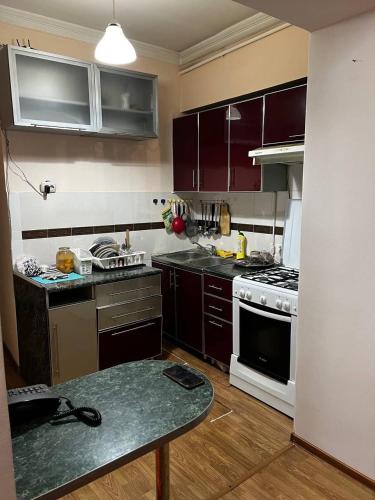 a kitchen with purple cabinets and a stove top oven at City Center Apartment in Tashkent