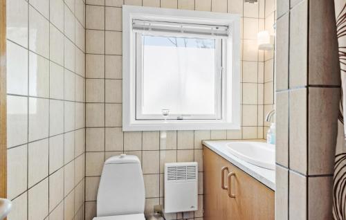 a bathroom with a toilet and a window at 3 Bedroom Stunning Home In Rudkbing in Spodsbjerg