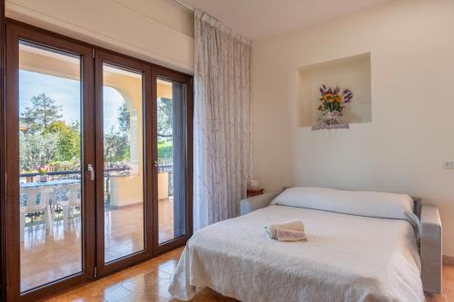 Schlafzimmer mit einem Bett und einer Glasschiebetür in der Unterkunft La Terrazza di Valeria in SantʼAgata sui Due Golfi