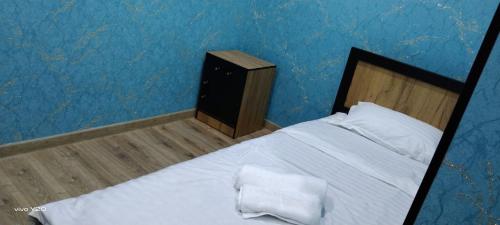a bedroom with a white bed and a blue wall at Volidam Hotel in Karmana