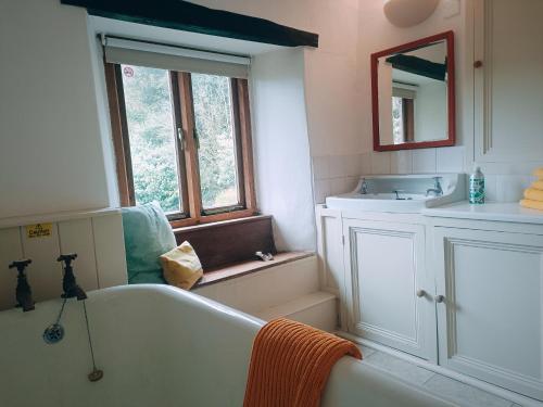 a bathroom with a bath tub and a sink at The Duddon Nest in Ulpha
