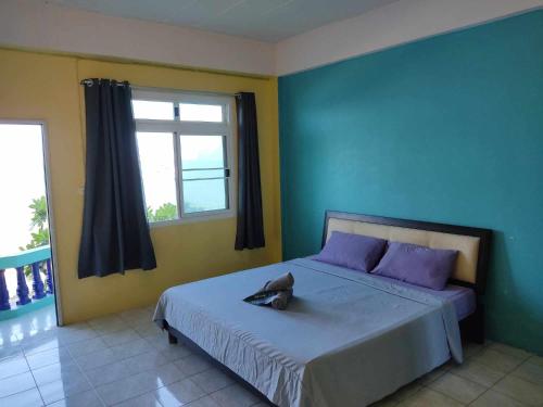 una camera da letto con un letto con cuscini viola e una finestra di Darin's Place a Prachuap Khiri Khan